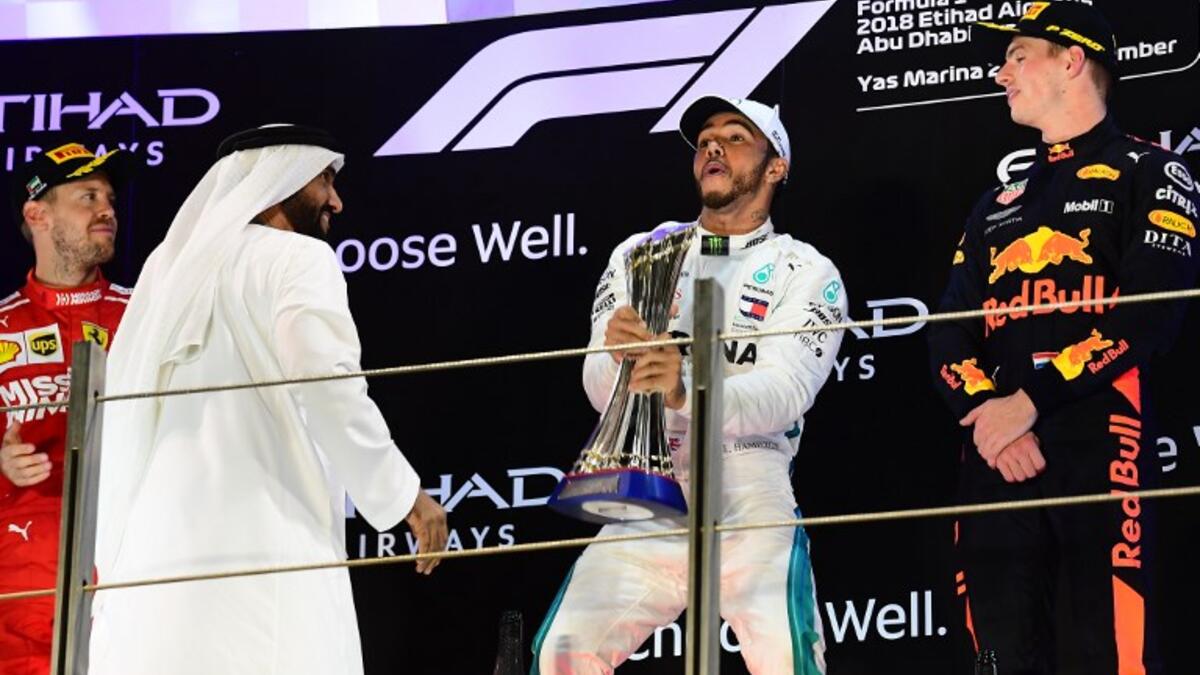 (From L) Ferrari's German driver Sebastian Vettel (2nd), Mercedes' British driver Lewis Hamilton (1st) and Red Bull's Dutch driver Max Verstappen (3rd) celebrate on the podium after the Abu Dhabi Formula One Grand Prix at the Yas Marina circuit on November 25, 2018, in Abu Dhabi. GIUSEPPE CACACE / AFP