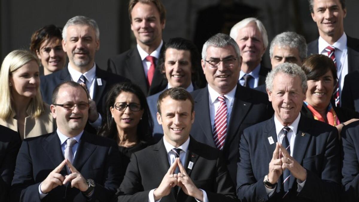 New French President Emmanuel Macron (C) poses next to the president of the IOC Evaluation Commission for the 2024 Olympics Patrick Baumann (L) and French member of the IOC Guy Drut (R) at the Elysee Palace in Paris after a meeting with members of the IOC Evaluation Commission, on May 16, 2017. STEPHANE DE SAKUTIN / AFP