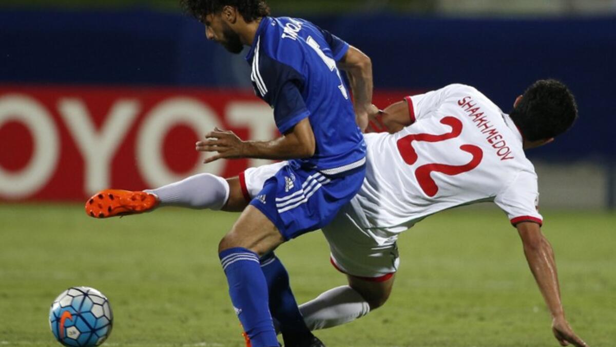 UAE's Al-Nasr club player Tariq Ahmed (L) tries to control the ball as Uzbekistan's Lokomotiv club player Sanjar Shaakhmedov falls to the ground during their Asian Champions League (AFC) group A football match at the Rashid Al-Maktoum Stadium in Dubai on April 20, 2016.
KARIM SAHIB / AFP