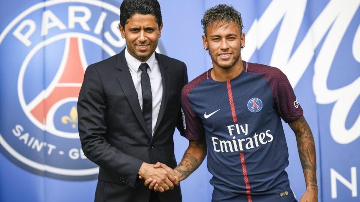 Brazil's Neymar (R) shakes hands with Paris Saint Germain's (PSG) Qatari president Nasser Al-Khelaifi during a press conference at the Parc des Princes stadium on August 4, 2017 in Paris after agreeing a five-year contract following his world record 222 million euro ($260 million) transfer from Barcelona to PSG. 
Lionel BONAVENTURE / AFP