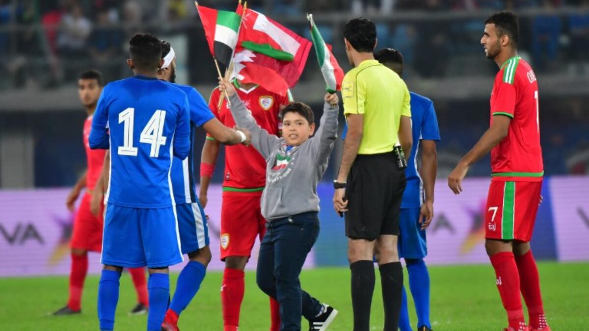A young football fan enters the pitch during the 2017 Gulf Cup of Nations football match between Kuwait and Oman at the Sheikh Jaber al-Ahmad Stadium in Kuwait City on December 25, 2017.

GIUSEPPE CACACE / AFP
