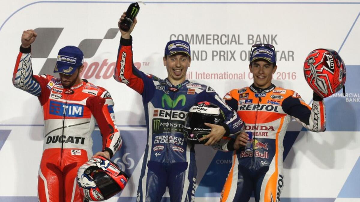 Spanish MotoGP rider Jorge Lorenzo (C) of the Movistar Yamaha MotoGP team celebrates on the podium after winning the Qatar MotoGP race with Italian rider Andrea Dovizioso (L) of the Ducati Team who won second place and Spanish rider Marc Marquez (R) third place at the Losail International Circuit in Doha on March 20, 2016.
KARIM JAAFAR / AFP