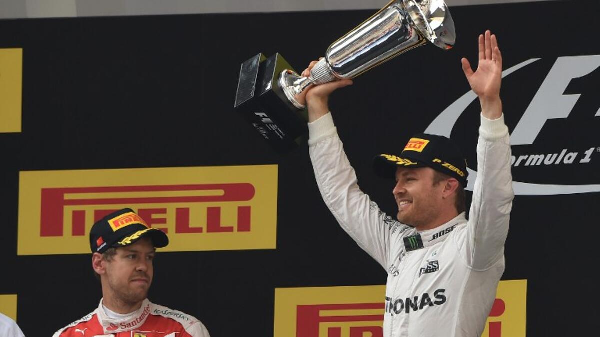 Mercedes AMG Petronas F1 Team's German driver Nico Rosberg (R) celebrates on the podium after winning the Formula One Chinese Grand Prix in Shanghai on April 17, 2016, as second-placed Ferrari driver Sebastian Vettel of Germany (R) looks on.
GREG BAKER / AFP