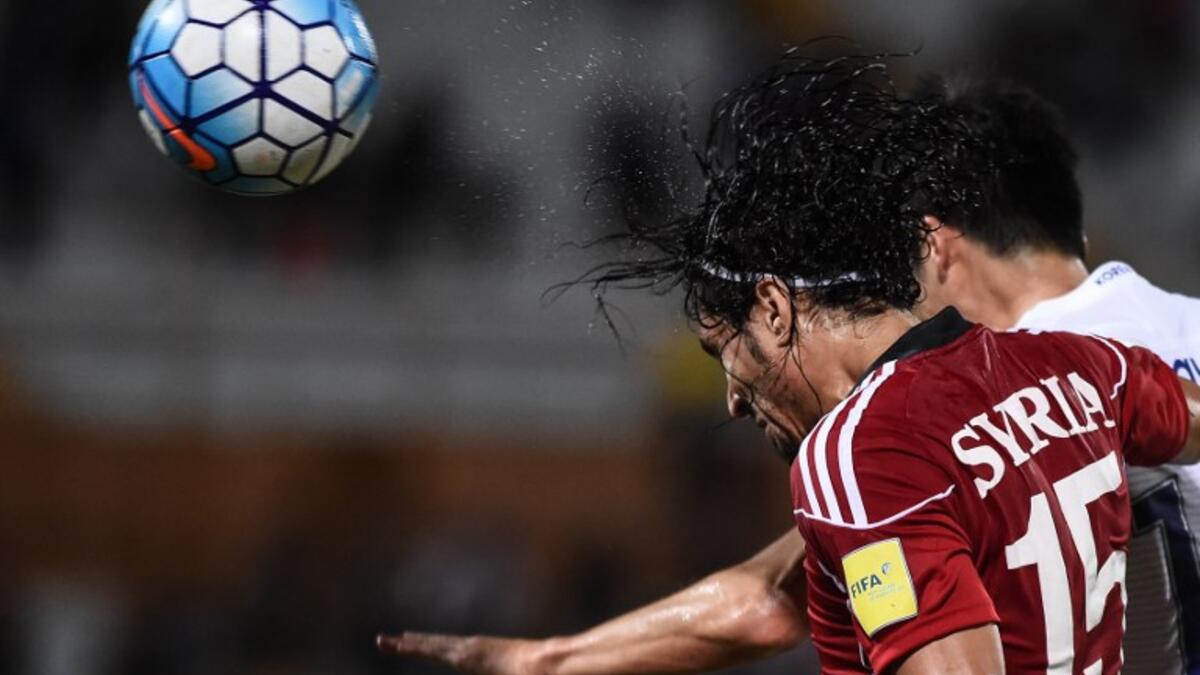 Alaa Al Shbbli of Syria (L) fights for the ball with Ki Sung Yueng of South Korea (R) during the 2018 World Cup qualifying football match between South Korea and Syria at Tuanku Abdul Rahman Stadium in Seremban on September 6, 2016.
MOHD RASFAN / AFP