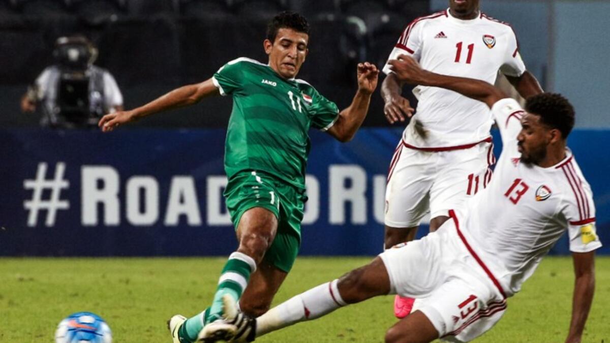 Iraq's Amjed Attwan (L) is tackled by UAE's Khamis Esmaeel during the 2018 World Cup qualifying football match between Iraq and the United Arab Emirates at Sheikh Mohammed Bin Zayed stadium in Abu Dhabi on November 15, 2016. Karim Sahib / AFP
