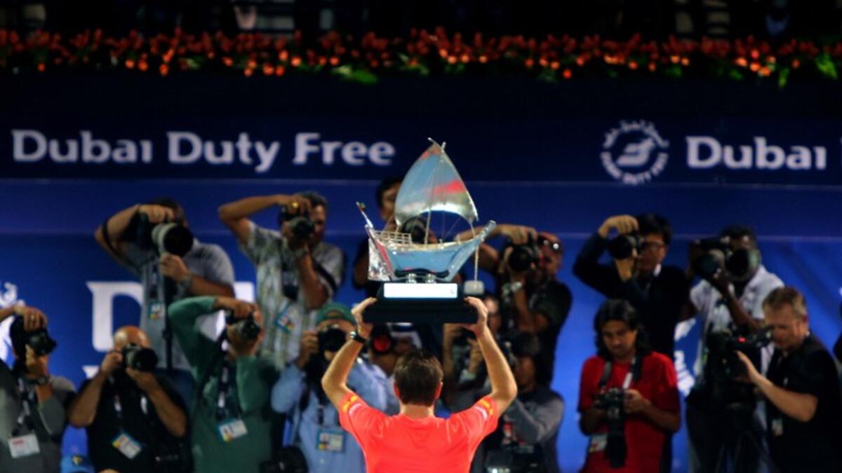 Stanislas Wawrinka of Switzerland poses with his trophy in front of journalists after beating Marcos Baghdatis of Cyprus in their ATP final tennis match of the Dubai Duty Free Tennis Championships on February 27, 2016. Wawrinka won 6-4, 7-6 (15/13). MARWAN NAAMANI / AFP