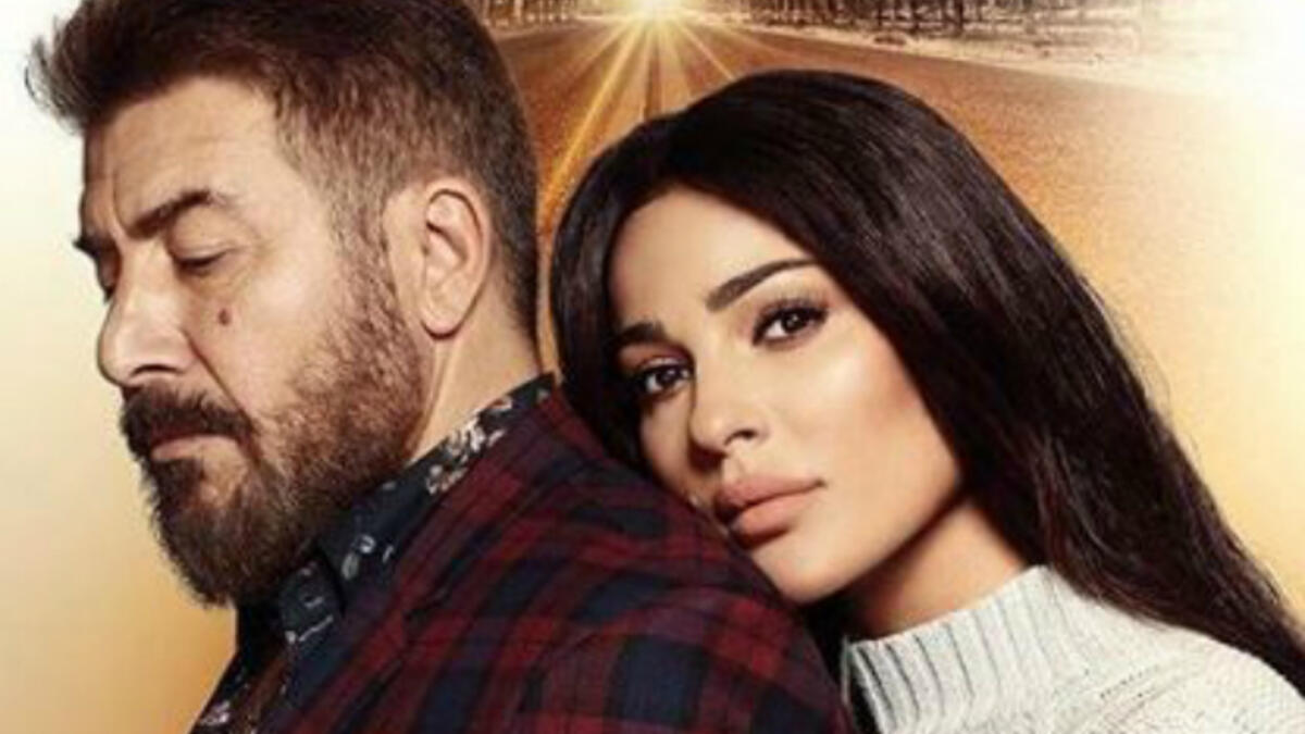 Miss Lebanon 2004 and actress Nadine Njeim is leaning on Syrian actor Abed Fahed's back in the poster of