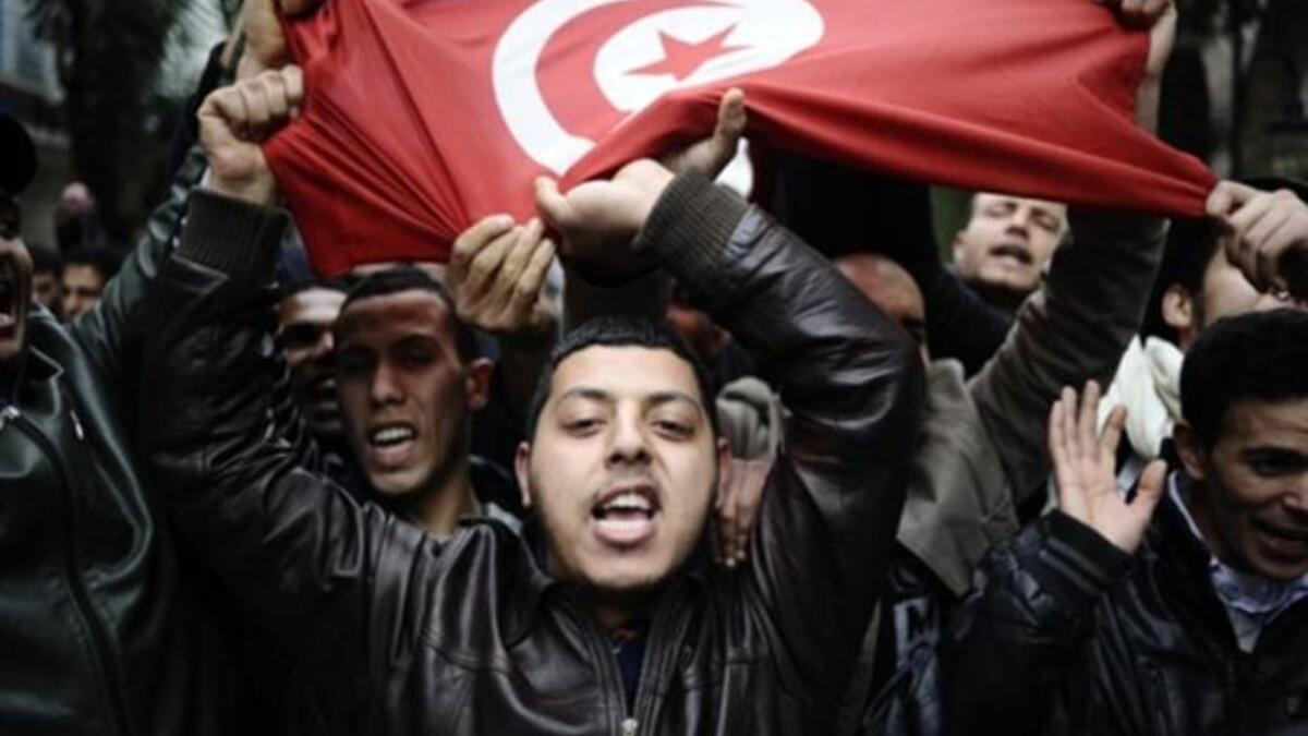 People holding a Tunisian flag during a protest in Tunis.