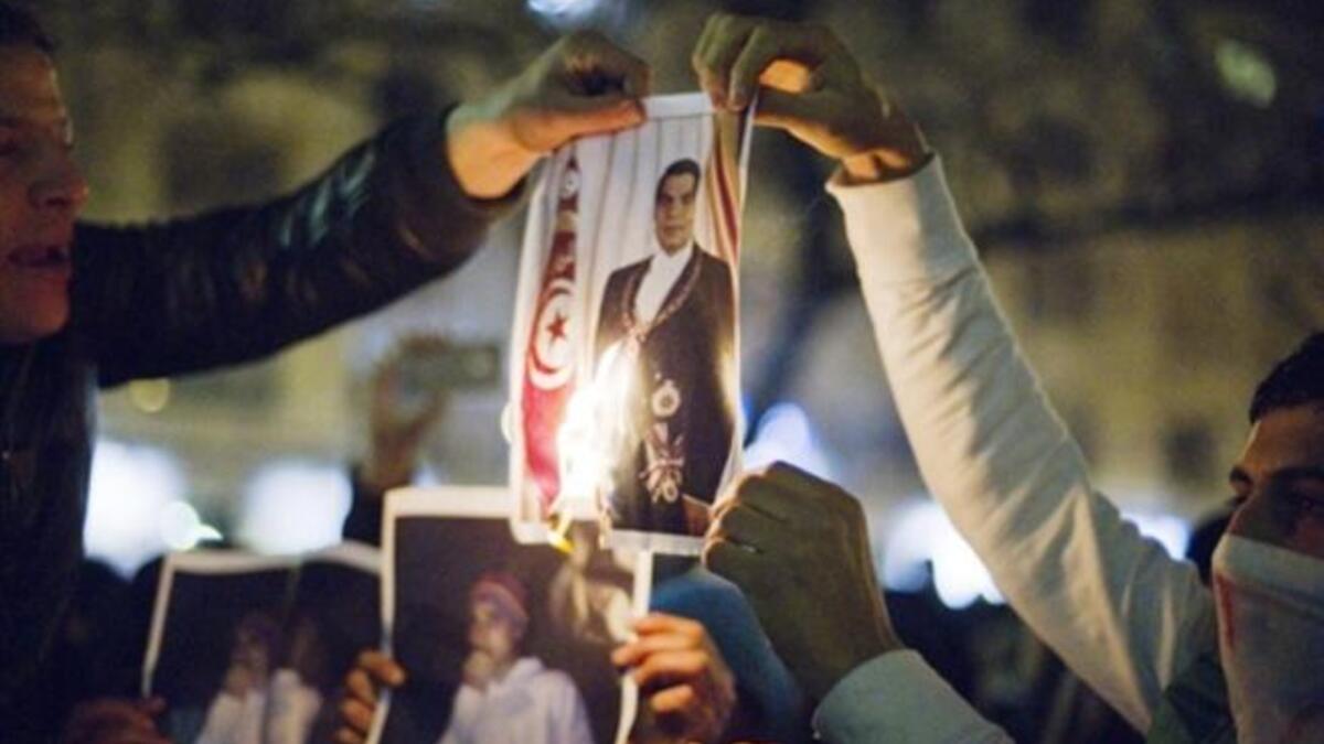 Men burn a picture of Tunisian President Zine El Abidine Ben Ali as they demonstrate against Ben Ali in Paris.