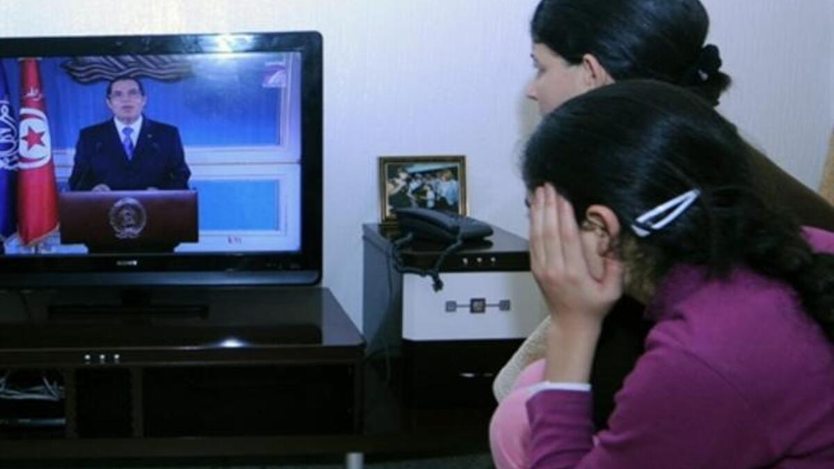 A Tunisian family watches TV as Tunisian President Ben Ali gives his speech. Police opened fire on demonstrators in the centre of the Tunisian capital Thursday, killing at least one person, witnesses said.