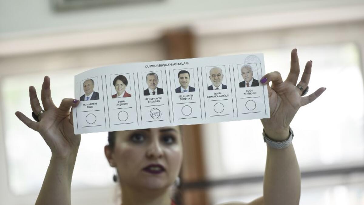 An election committee member shows a ballot displaying a vote for Recep Tayyip Erdogan, Turkish President and leader of the Justice and Development Party (AKP) at a polling station during the Turkish presidential and parliamentary elections in Istanbul on June 24, 2018. (Yasin AKGUL / AFP)