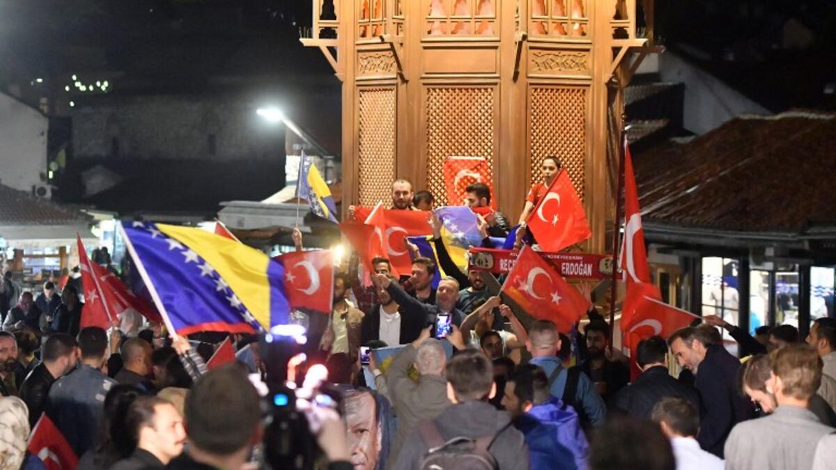 Turkish nationals, supporters of president Recep Tayyip Erdogan, currently residing in Bosnia and Herzegovina, cheer in downtown Sarajevo, late on June 24, 2018. After 15 years in office that have already transformed his country, President Recep Tayyip Erdogan is set to return to power. (STR / AFP)