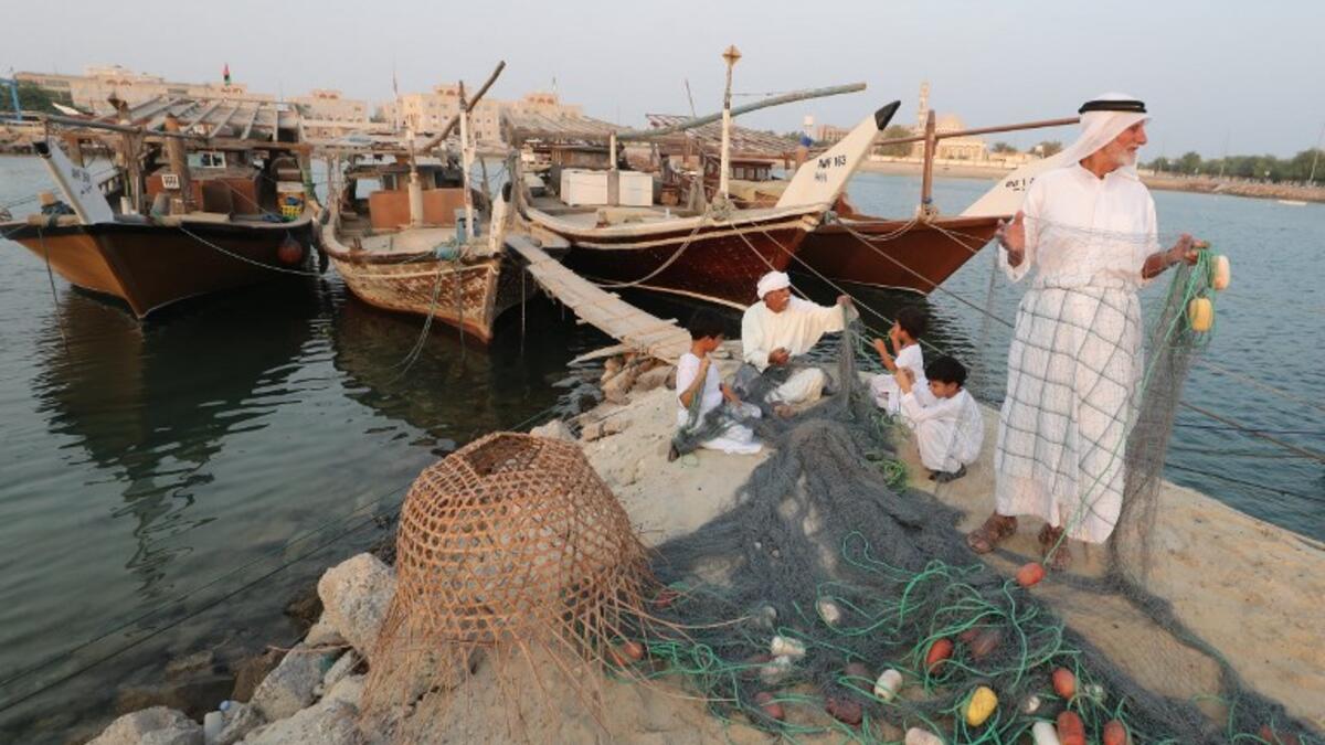Emirati men train children on handicraft industries during the Dalma Sailing Festival. (KARIM SAHIB / AFP)