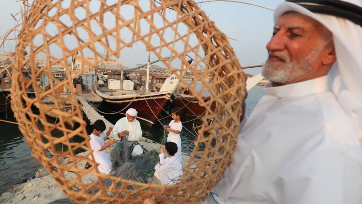 Emiratis train their children on handicraft industries during the Dalma Sailing Festival. (KARIM SAHIB / AFP)