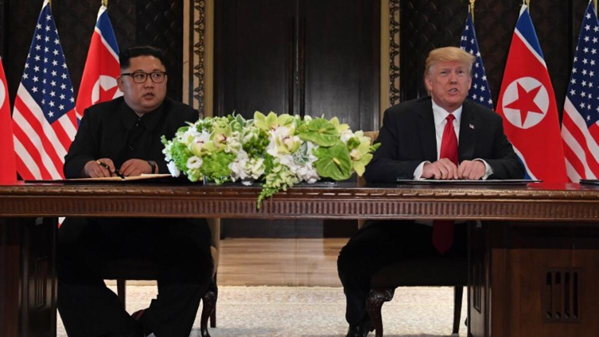 US President Donald Trump (R) speaks while seated with North Korea's leader Kim Jong Un (L) at a signing ceremony during their historic US-North Korea summit, at the Capella Hotel on Sentosa island in Singapore on June 12, 2018. (SAUL LOEB / AFP)