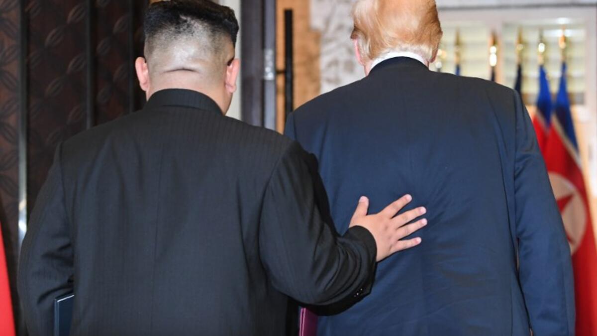 North Korea's leader Kim Jong Un (L) and US President Donald Trump leave following a signing ceremony during their historic US-North Korea summit, at the Capella Hotel on Sentosa island in Singapore on June 12, 2018.  (SAUL LOEB / AFP)