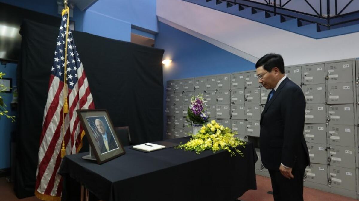 Vietnamese Deputy Prime Minister Pham Binh Minh pays repect to the late US Senator John McCain during a memorial tribute at the US embassy in Hanoi on August 27, 2018.  (Nhac NGUYEN / AFP)