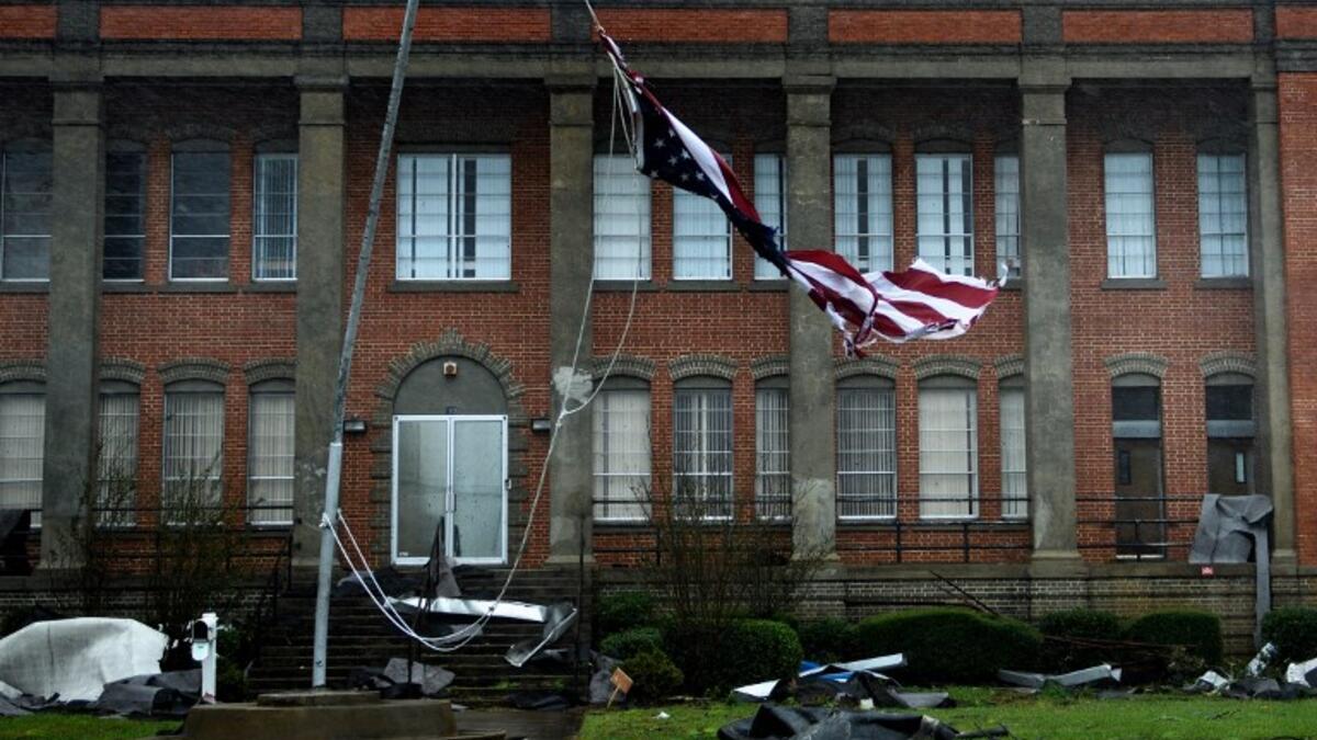 An American flag is torn in front of a school during Hurricane Michael October 10, 2018 in Panama City, Florida. (Brendan Smialowski / AFP)