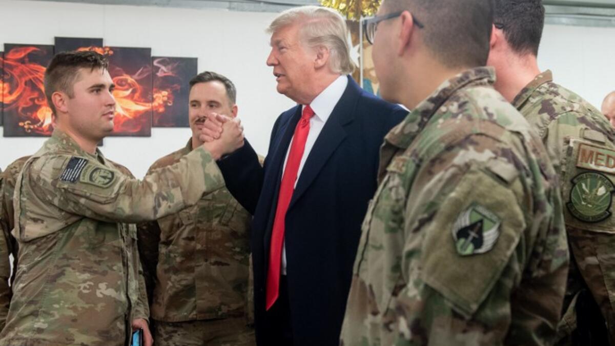 US President Donald Trump greets members of the US military during an unannounced trip to Al Asad Air Base in Iraq on December 26, 2018. 
SAUL LOEB / AFP