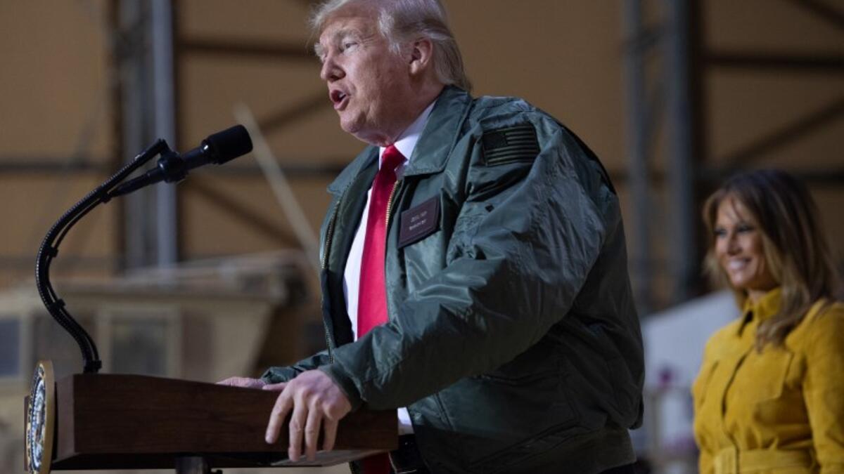 US President Donald Trump speaks to members of the US military as First Lady Melania Trump looks on during an unannounced trip to Al Asad Air Base in Iraq, December 26, 2018.
SAUL LOEB / AFP
