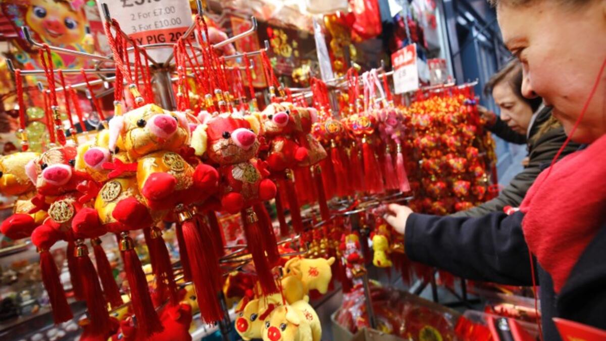 People look at festive New Year pig ornaments in the China Town area of London on February 5, 2019.
Tolga AKMEN / AFP