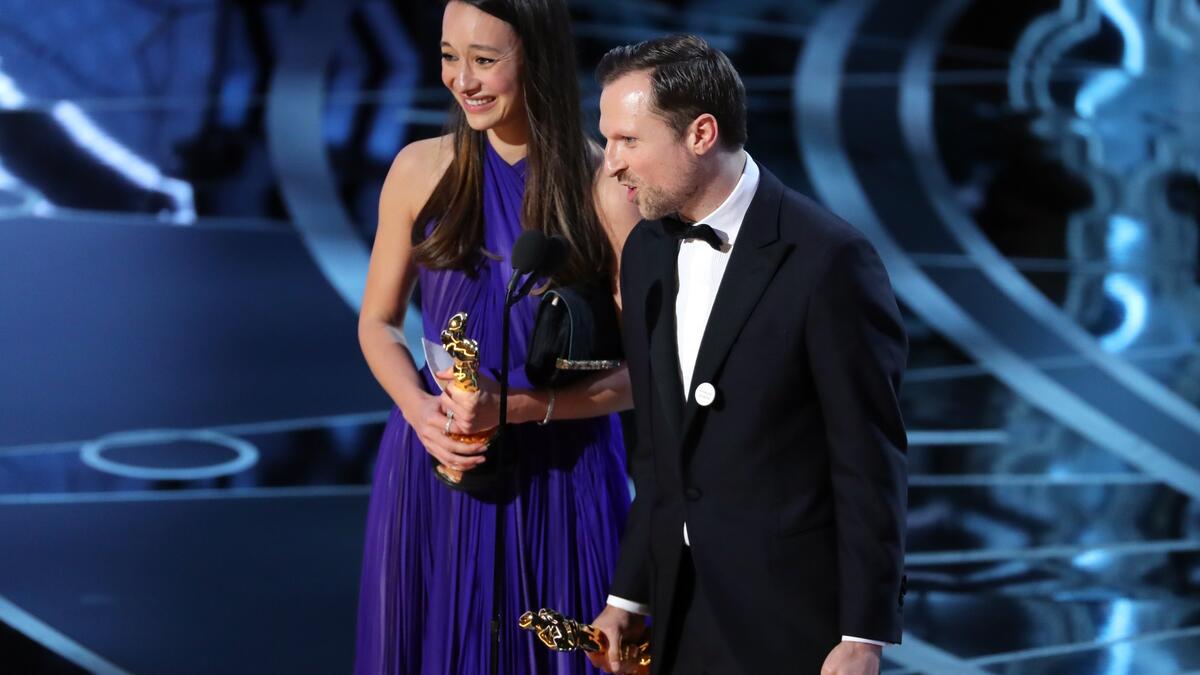 المنتجة جوانا نتاسيغارا، والمخرج رلاندو فون إنزدل، يتسلمان الجائزة عن أفضل فيلم وثائقي قصير "الخوذات البيضاء". يحكي الفيلم قصة متطوعي الدفاع المدني السوريين الذين خاطروا بأرواحهم لإنقاذ الضحايا من الغارات الجوية، والذي منع مصوره من حضور الحفل بسبب قرار ترامب.