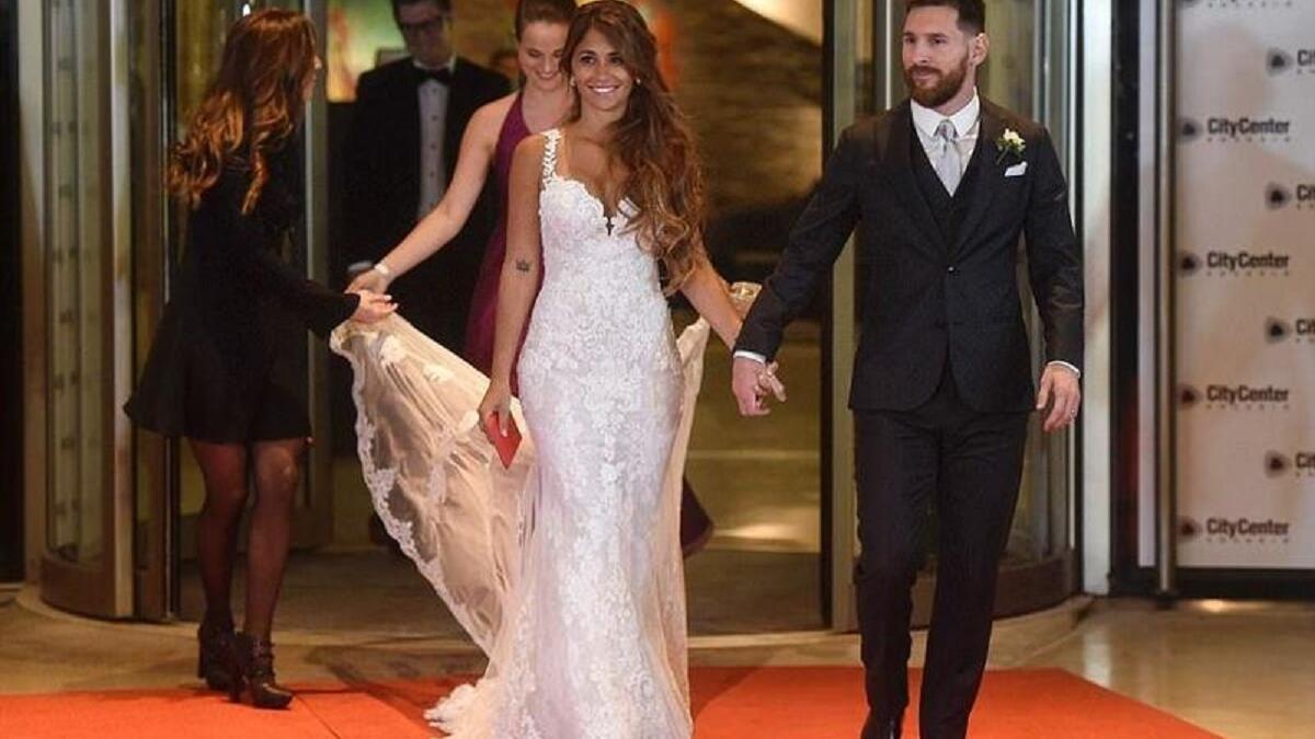 نجم منتخب الأرجنتين ونادي برشلونة الإسباني ليونيل ميسيي وزوجته أنطونيلا روكوزو يدخلان قاعة الزفاف وخلفهما شقيقة العروس تحمل ذيل الفستان.