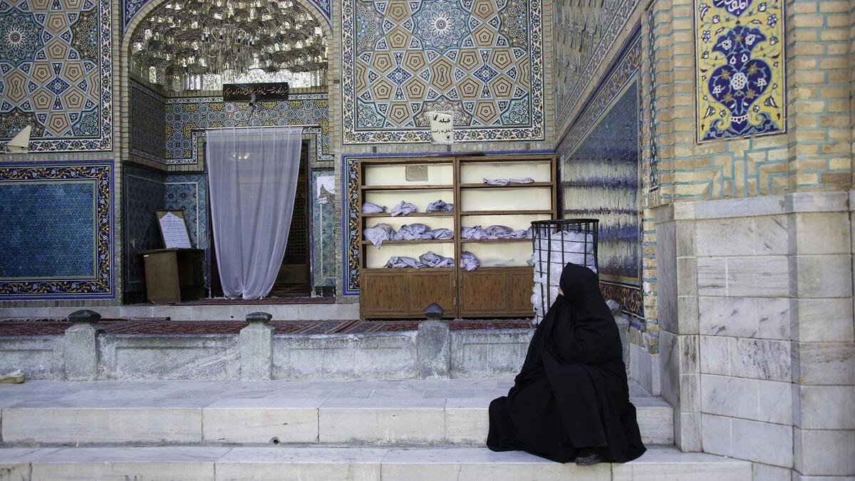 A Persian lady dressed in chador mesmerised by the magnificent architecture in Iran (static1.squarespace.com)