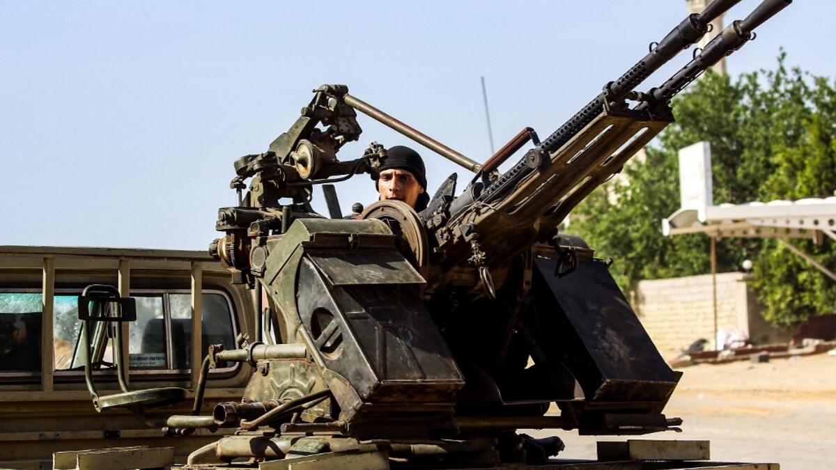 A Libyan fighter loyal to the Government of National Accord (GNA) mans a turret mounted on the back of a pickup truck during clashes with forces loyal to strongman Khalifa Haftar south of the capital Tripoli's suburb of Ain Zara, on April 10, 2019. Mahmud TURKIA / AFP