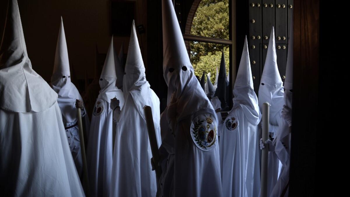Penitents of the 'La Paz' brotherhood parade during a Palm Sunday procession in Sevilla as part of the Holy Week on April 14, 2019.  CRISTINA QUICLER / AFP