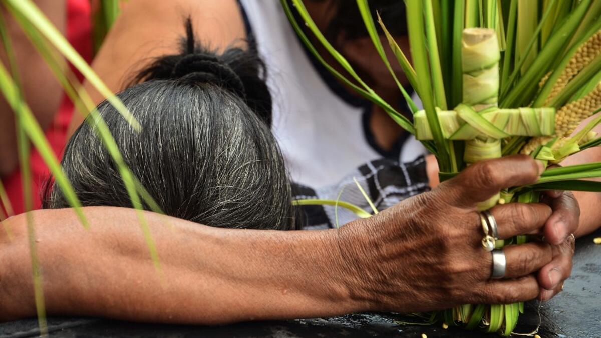 A Catholic faithful takes part in the traditional Palm Sunday procession in Tegucigalpa on April 14, 2019. For Christians, Palm Sunday marks the beginning of Holy Week, and commemorates Christ's triumphant entry into Jerusalem, before his arrest, trial, crucifixion and resurrection. It is traditionally marked by a procession and special mass.  ORLANDO SIERRA / AFP
