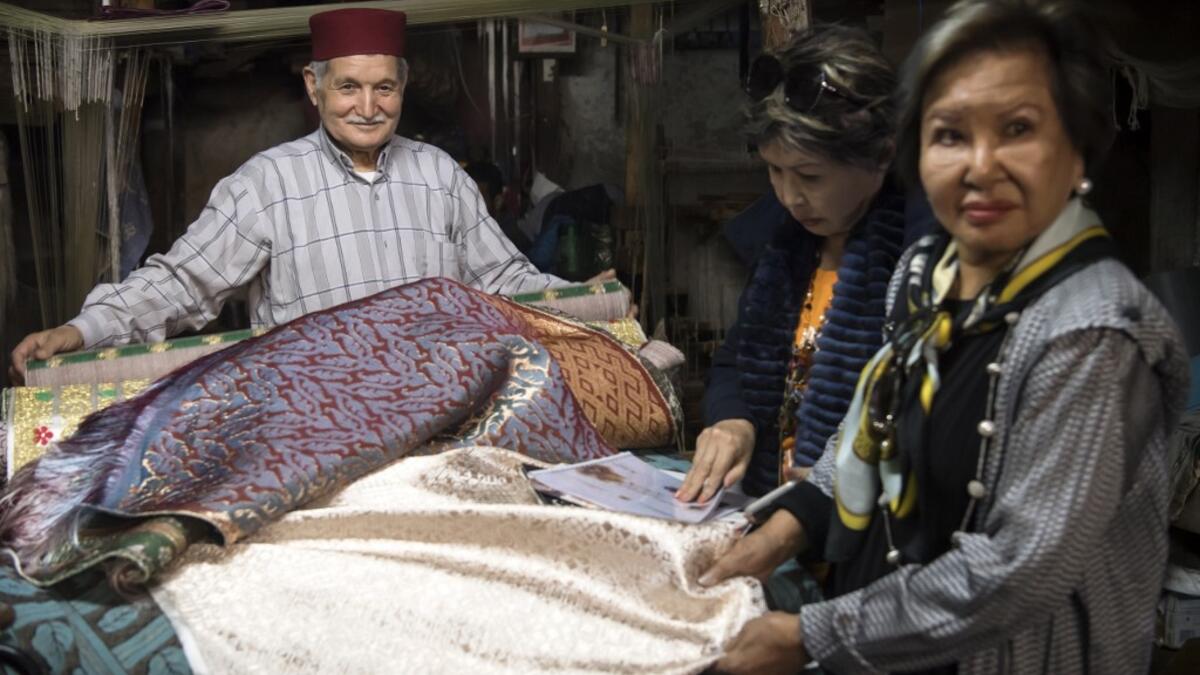 Abdelkader Ouazzani, the last of Morocco's brocade master weavers, displays tapestry at his workshop in the old city of Fez on April 10, 2019. His skilfull hands intricately create shimmering silk fabrics, enhanced with gold or silver thread, for bridal jewellery, designer creations or high-end furnishings. FADEL SENNA / AFP