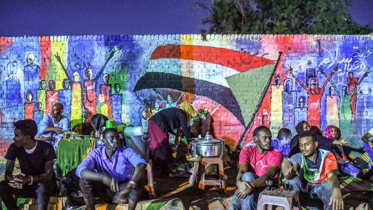 Sudanese protesters sit in front of a recently painted mural during a demonstration near the army headquarters in the capital Khartoum  OZAN KOSE / AFP