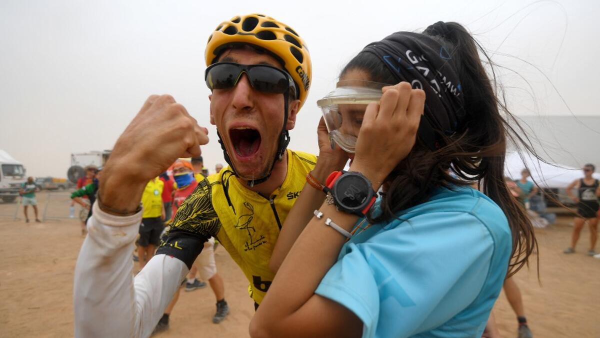 Sapin's Alex Roca Campillo celebrates with girlfriend at the end of Stage 5 of the 14th edition of Titan Desert 2019 mountain biking race between M’ssici and El Jorf, in Morocco, on May 2, 2019. Campillo is the first person living with cerebral palsy to participate in the Titan race. FRANCK FIFE / AFP