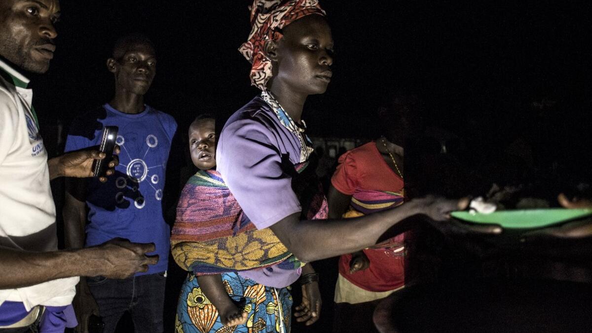 South Sudanese Refugees receive food after being transported from the border of South Sudan and the Democratic Republic of the Congo (DRC) to a refugee settlement site  JOHN WESSELS / AFP