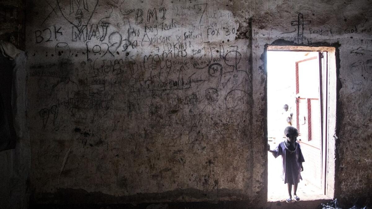 A young South Sudanese Refugee stands on the doorstep of a building located in a transition camp for South Sudanese refugees who have just arrived in Aru. JOHN WESSELS / AFP