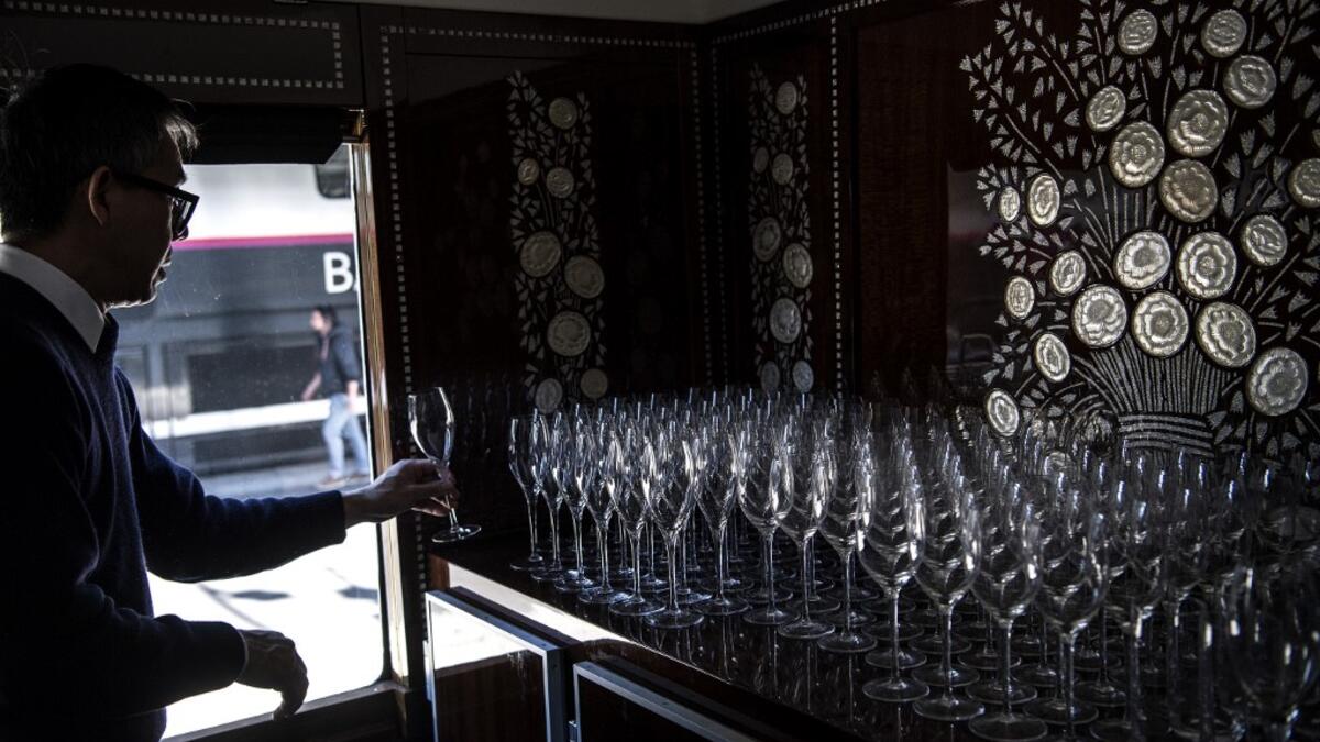 This picture taken on May 13, 2019 shows a bartender lining up glasses in the dining car of a restored carriage of an Orient Express train displayed at the Gare de l'Est train station in Paris.  Christophe ARCHAMBAULT / AFP