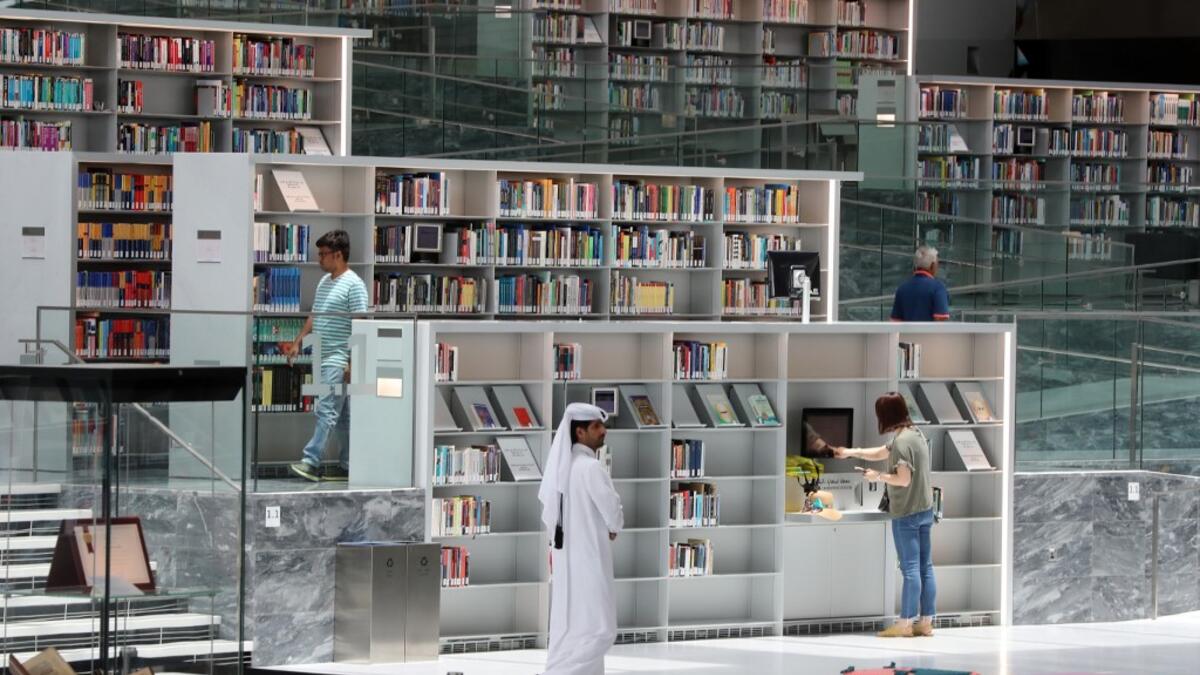 People walk through the aisles of the Qatar National Library in the capital.  KARIM JAAFAR / AFP