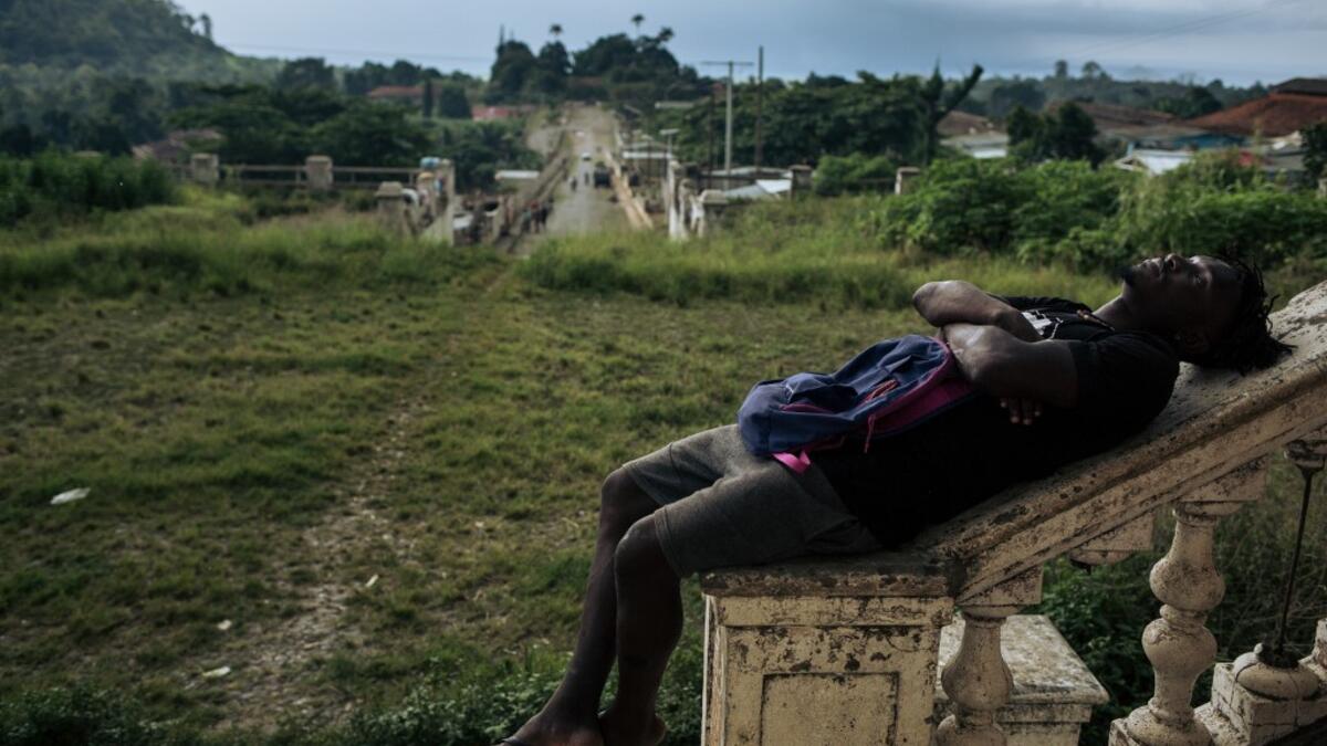 Willy, inhabitant of the roca Agostinho Neto, an abandoned cocoa plantation of Sao Tome and Principe, sleeps in front of the abandoned hospital of the roca, on May 12, 2019.  Alexis HUGUET / AFP