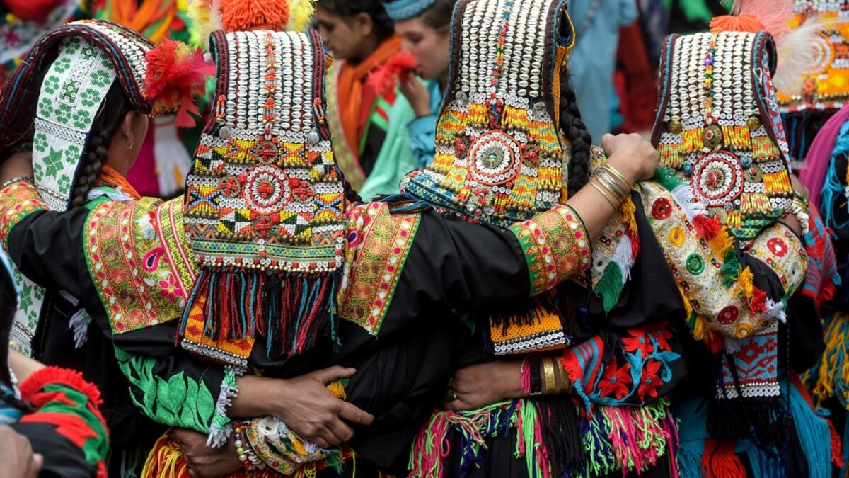Kalash women wearing traditional dresses dance as they celebrate 'Joshi', a festival to welcome the arrival of spring, at Bumburate village in the mountainous valleys in northern Pakistan.  AAMIR QURESHI / AFP