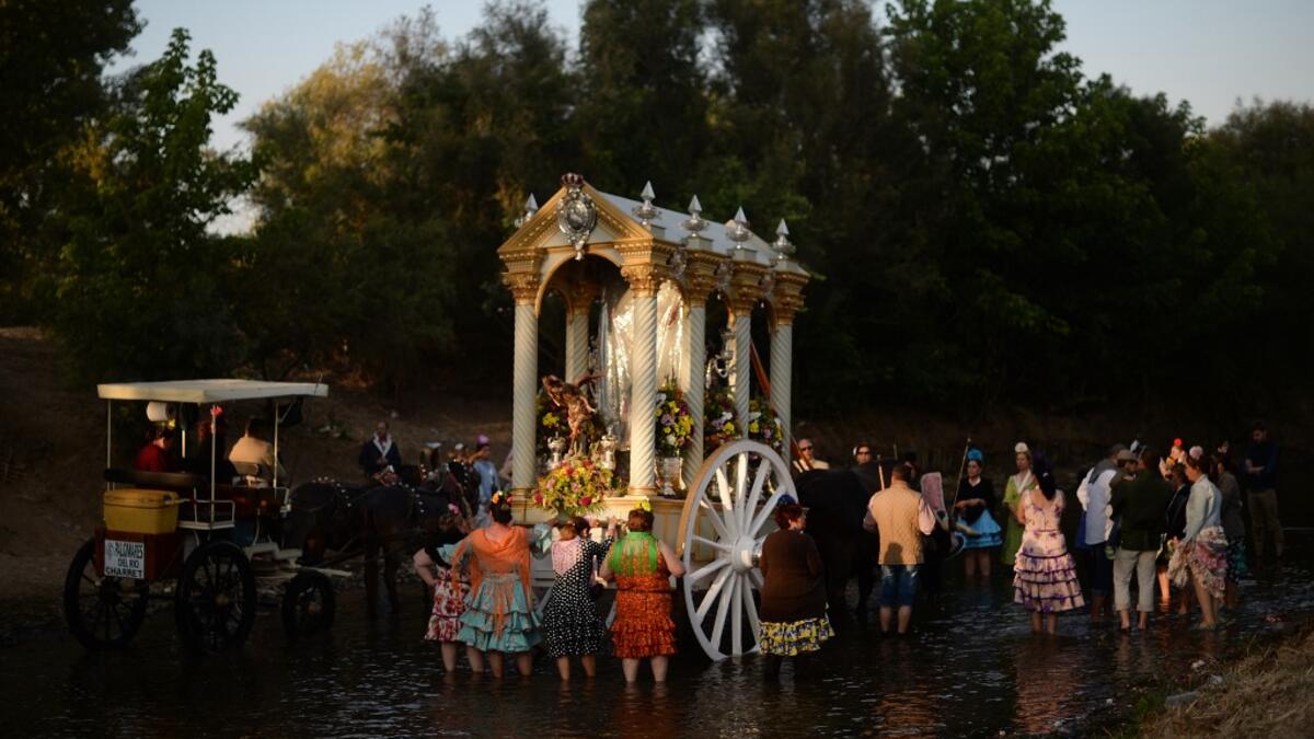 Pilgrims cross the Quema river in Villamanrique, during a pilgrimage on their way to the village of El Rocio. CRISTINA QUICLER / AFP
