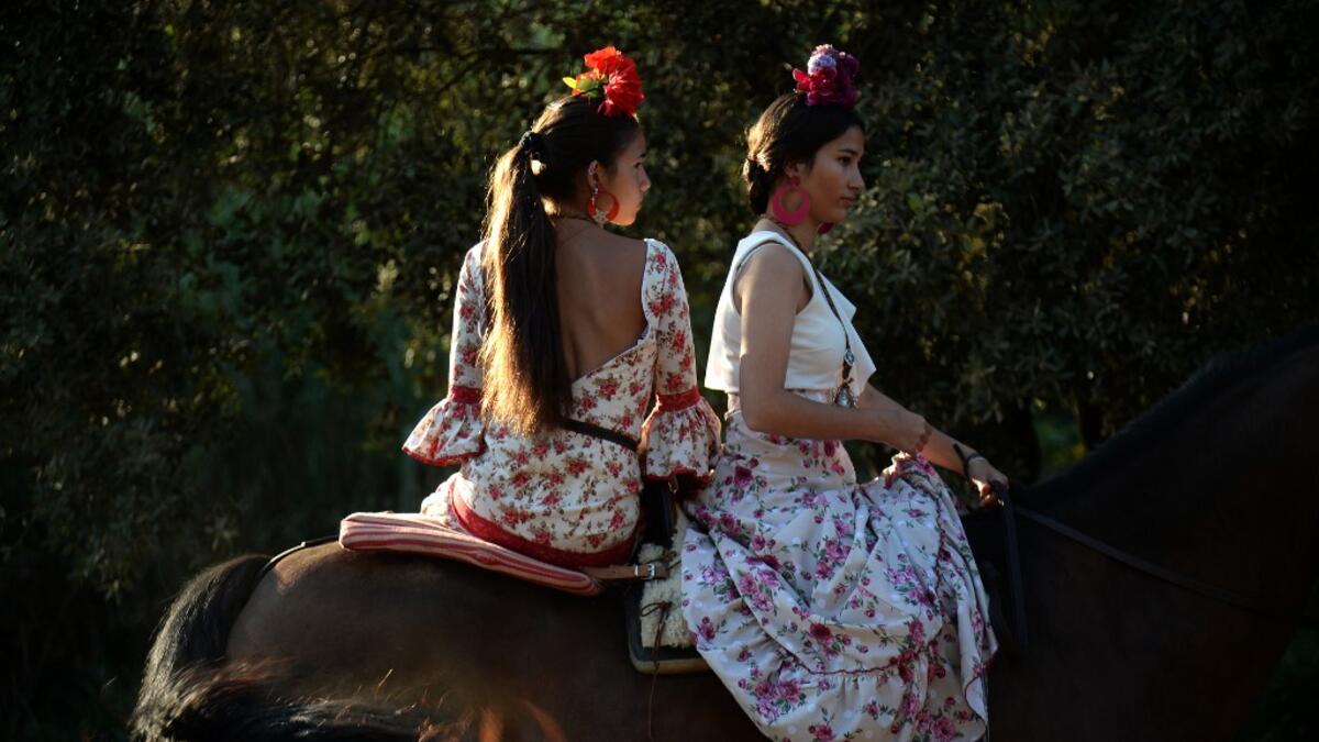 El Rocio pilgrimage, the largest in Spain, gathers hundreds of thousands of devotees in traditional outfits converging in a burst of colour as they make their way on horseback and on board decorated carriages across the Andalusian countryside. CRISTINA QUICLER / AFP