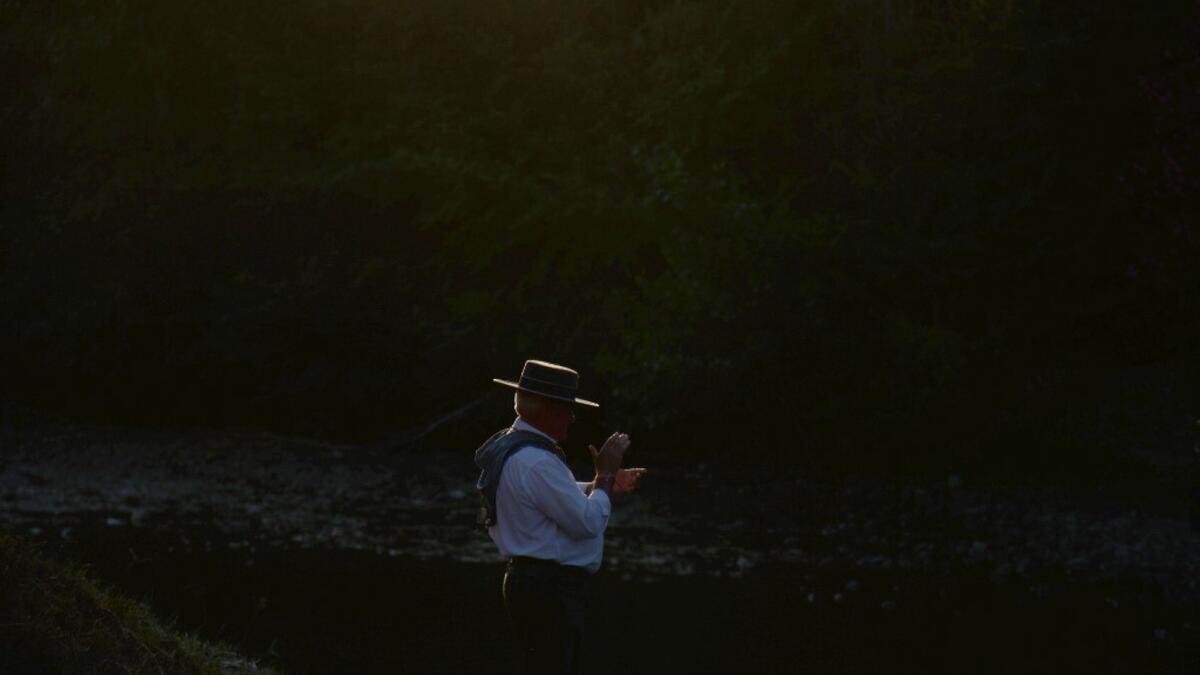 A pilgrim walks by an effigy of a Virgin near the Quema river in Villamanrique, during a pilgrimage to the village of El Rocio. CRISTINA QUICLER / AFP