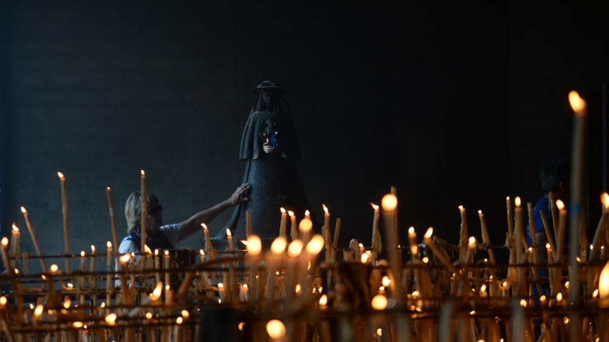 A pilgrim touches the effigy of the Rocio Virgin at the church of the village of El Rocio  CRISTINA QUICLER / AFP