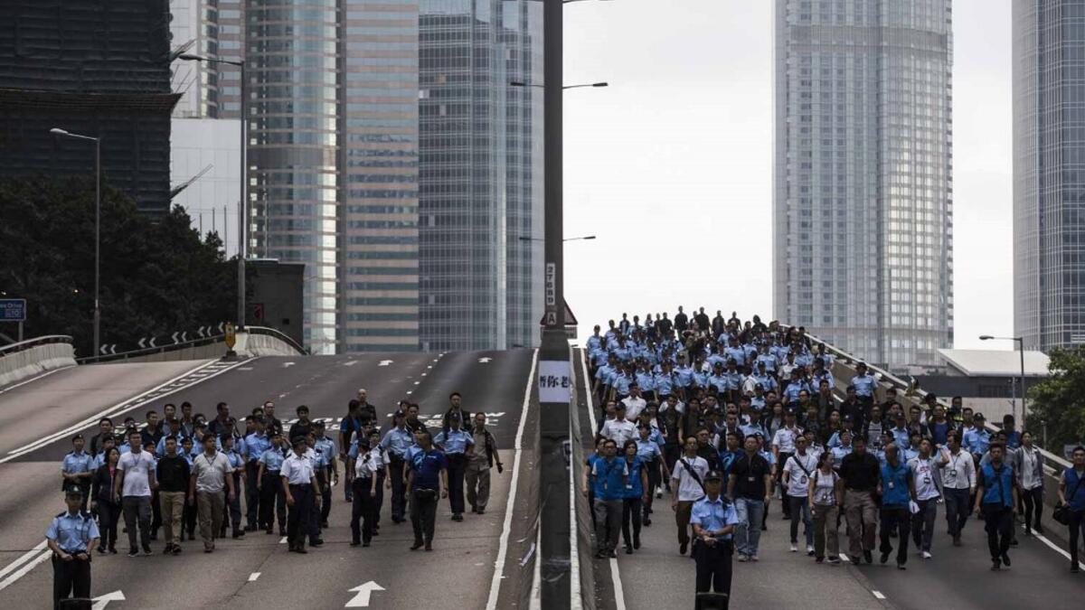 Police arrive to negotiate with protesters to clear a road in Hong Kong early.  ISAAC LAWRENCE / AFP