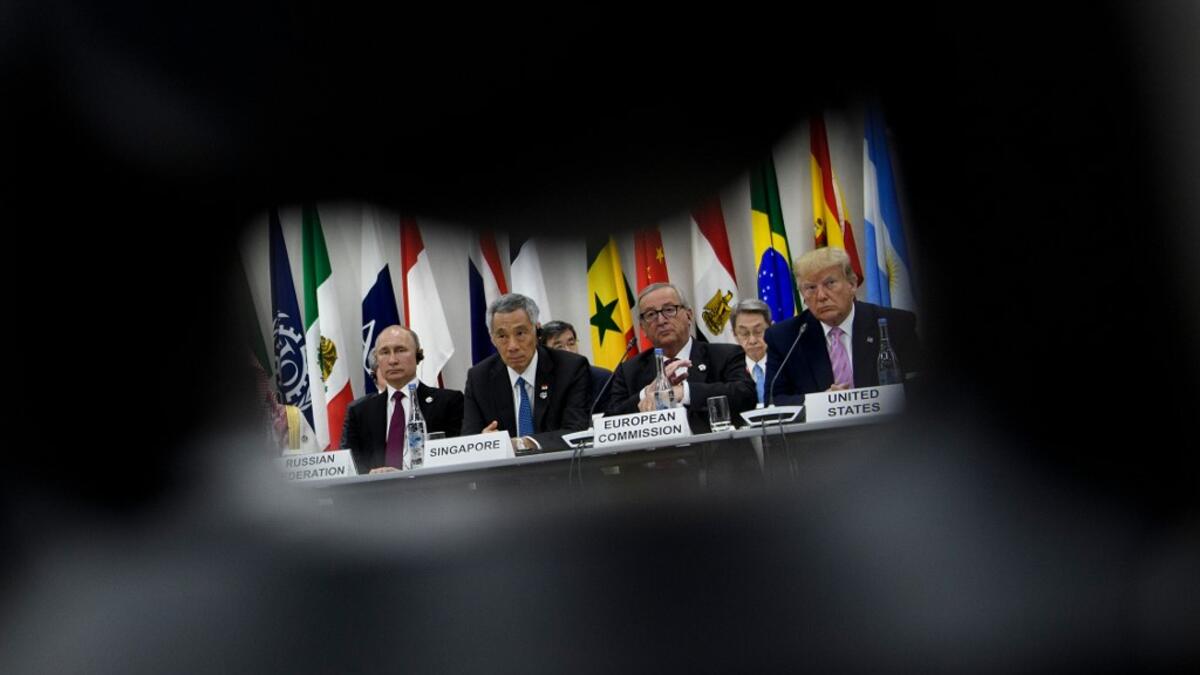(from left) Russia's President Vladimir Putin, Singapore's Prime Minister Lee Hsien Loong, President of the European Commission Jean-Claude Juncker and US President Donald Trump listen during a meeting at the G20 Summit in Osaka on June 28, 2019.  Brendan Smialowski / AFP