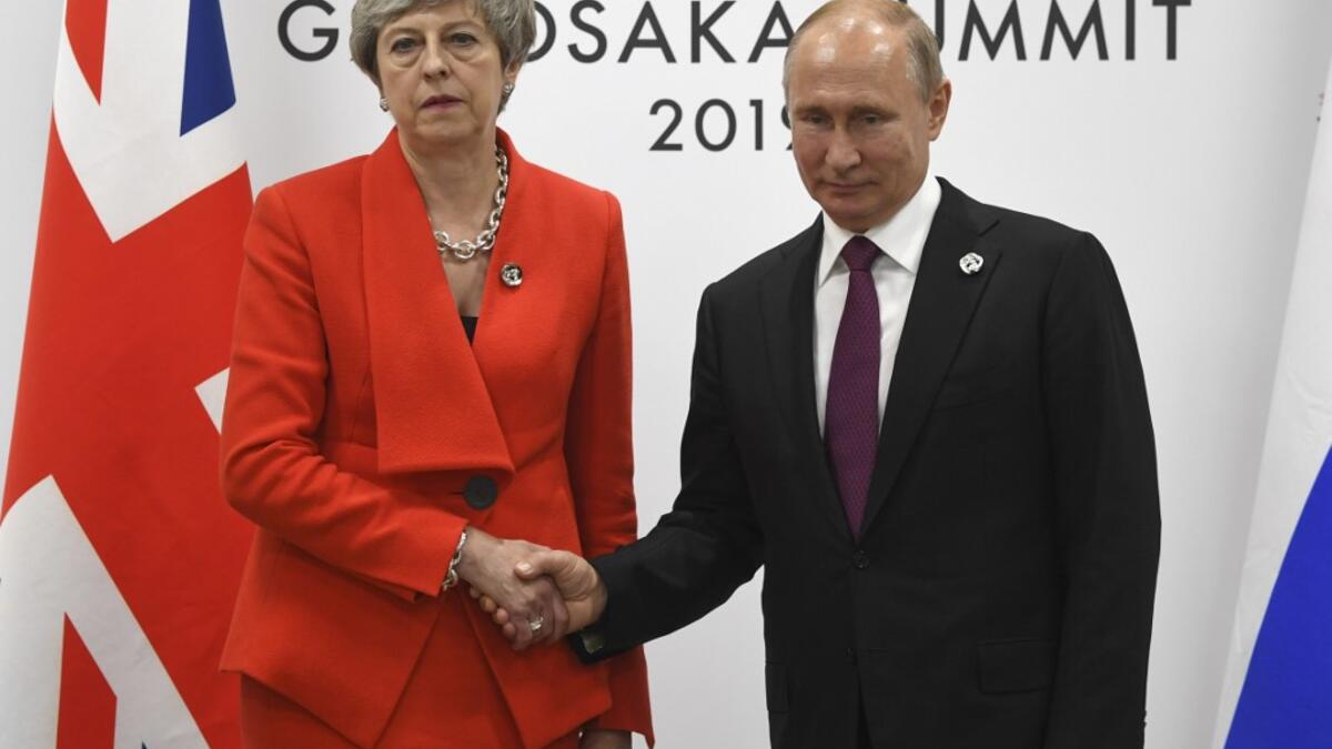 Russian President Vladimir Putin and British Prime Minister Theresa May shake hands during their meeting on the sidelines of the G20 summit in Osaka on June 28, 2019.  STR / POOL / AFP