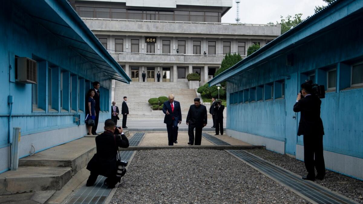 North Korea's leader Kim Jong Un stands with US President Donald Trump north of the Military Demarcation Line that divides North and South Korea, in the Joint Security Area (JSA) of Panmunjom in the Demilitarized zone (DMZ) on June 30, 2019.  Brendan Smialowski / AFP