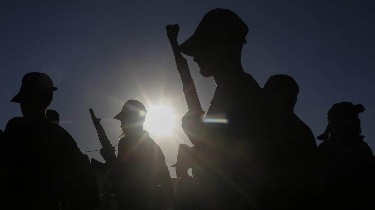 Palestinian youth, carrying wooden rifles, take part in a military-style graduation ceremony organised by the Islamic Jihad movement in Gaza City on July 4, 2019.  MOHAMMED ABED / AFP
