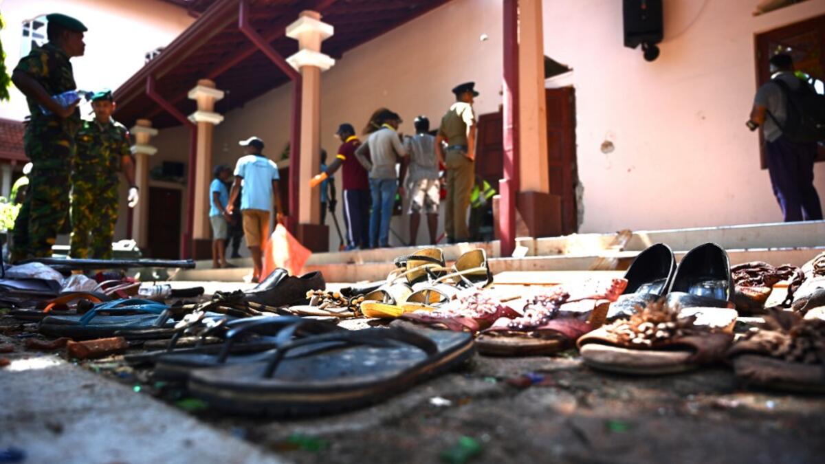 Shoes of victims are kept as evidence as security personnel inspect the interior of St Sebastian's Church in Negombo on April 22, 2019, a day after the church was hit in series of bomb blasts targeting churches and luxury hotels in Sri Lanka. Jewel SAMAD / AFP
